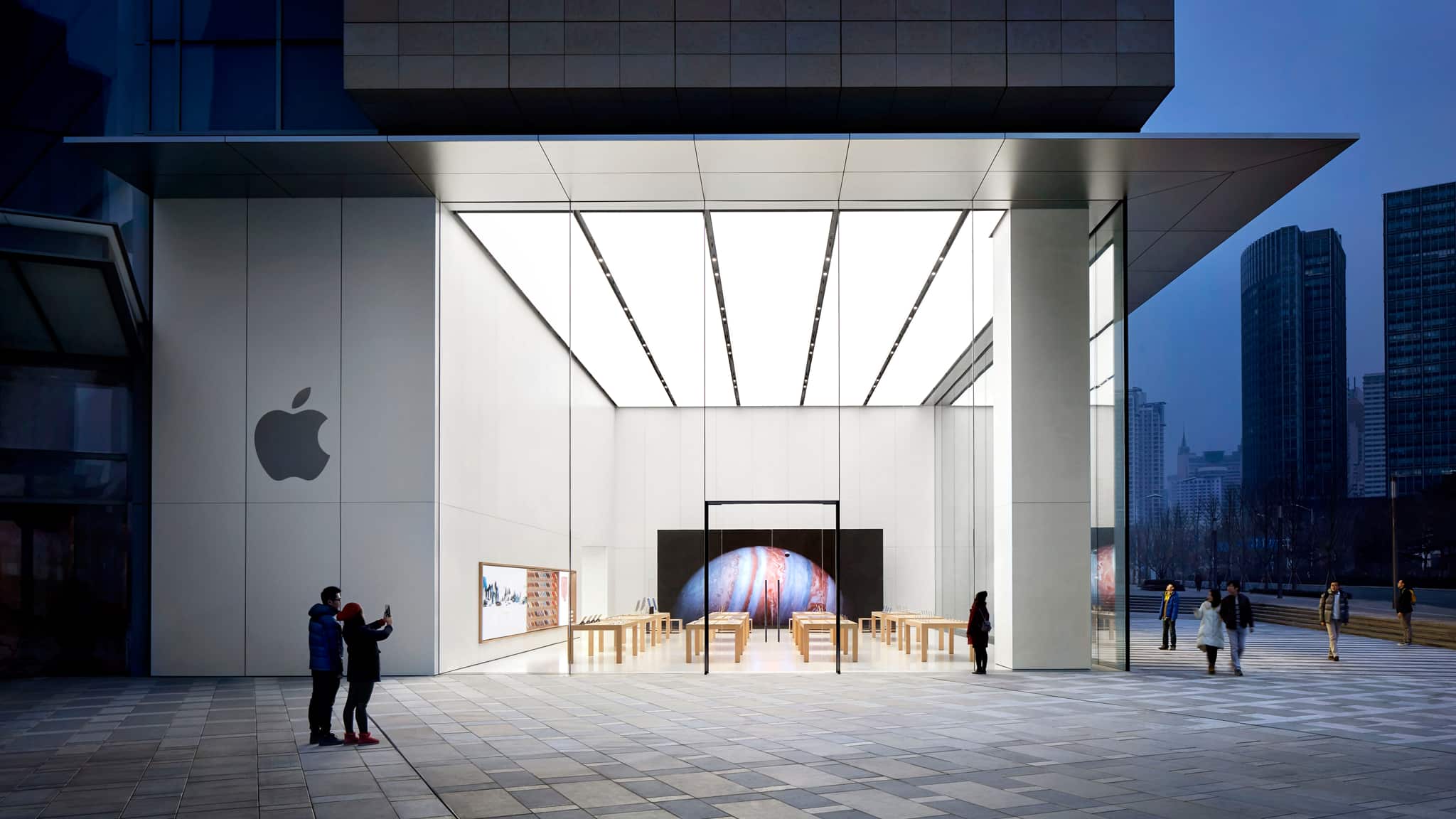 Exterior view of Apple MixC Qingdao, the first store in the city. The exterior storefront features an open corner with glazing on two sides with a 9 meter ceiling height.