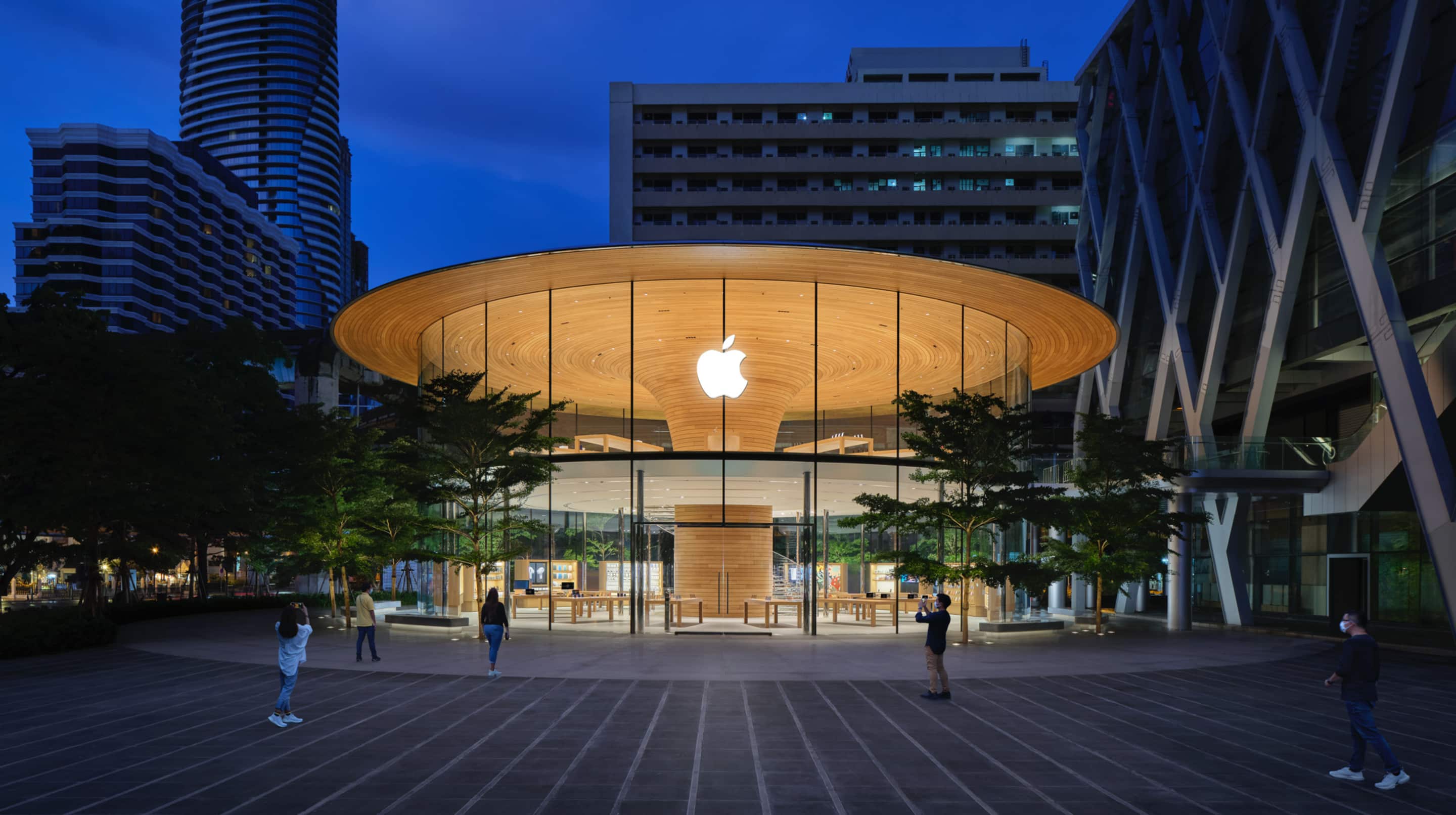Exterior view of Apple Central World, located at the heart of Ratchaprasong, one of the most significant retail areas in Bangkok. The store features first of kind 80 feet diameter glass cylinder design with 2 levels of sales area and the wooden ceiling has a unique center-cantlievered circular “Tree” structure.